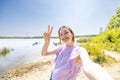 Happy young millenial woman with long brown hair taking a selfie portrait hiking along a forest lake trail, Pov of a Royalty Free Stock Photo