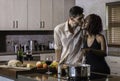 Happy young mixed race couple cooking dinner in kitchen Royalty Free Stock Photo