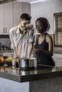 Happy young mixed race couple cooking dinner in kitchen Royalty Free Stock Photo