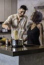 Happy young mixed race couple cooking dinner in kitchen Royalty Free Stock Photo