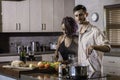 Happy young mixed race couple cooking dinner preparing food in the kitchen Royalty Free Stock Photo