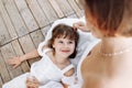 Happy young mom and child girl sitting near lake, pond. Mother and daughter smiling while spending free time outdoors Royalty Free Stock Photo