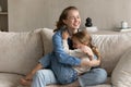 Happy young mom cuddling, embracing little daughter kid with love, Royalty Free Stock Photo