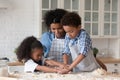 Happy young mom helping little sibling kids to make biscuits Royalty Free Stock Photo