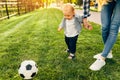 Happy young mom and her little son play soccer together outdoors Royalty Free Stock Photo