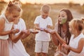 Happy young moms playing with their kids outdoors in summer. Happy family time together concept. selective focus Royalty Free Stock Photo