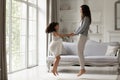 Happy mother and cute little daughter jumping in living room Royalty Free Stock Photo