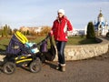 Happy young mother with baby in buggy Royalty Free Stock Photo