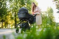 Happy young mother with baby in buggy walking in autumn park Royalty Free Stock Photo