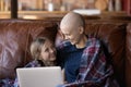 Happy young mother with cancer and daughter girl using laptop Royalty Free Stock Photo