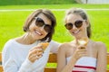 Happy young mother and cute daughter of a teenager in a city park eating ice cream, talking and laughing Royalty Free Stock Photo