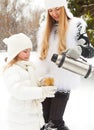 Happy young mother with daughter on winter picnic Royalty Free Stock Photo