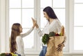 Happy young mother giving her little daughter a high five after grocery shopping Royalty Free Stock Photo