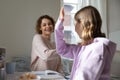 Happy young mother giving high five to smiling teen daughter. Royalty Free Stock Photo