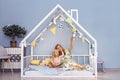 Happy young mother and her adorable daughter looking up and showing something interesting while sitting on bed Royalty Free Stock Photo