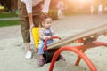 Happy young mother with her baby girl playing in colorful playground for kids. Mom with toddler having fun at summer park. Royalty Free Stock Photo