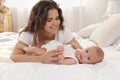 Happy young mother with her cute baby on bed at home Royalty Free Stock Photo