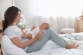 Happy young mother with her baby on bed at home Royalty Free Stock Photo