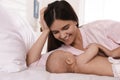 Happy young mother with her cute baby on bed at home Royalty Free Stock Photo