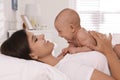 Happy young mother with her cute baby on bed at home Royalty Free Stock Photo