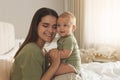 Happy young mother with her cute baby on bed at home Royalty Free Stock Photo