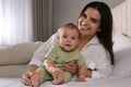 Happy young mother with her cute baby on bed at home Royalty Free Stock Photo