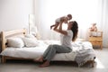 Happy young mother with her cute baby on bed at home Royalty Free Stock Photo