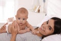 Happy young mother with her cute baby on bed at home Royalty Free Stock Photo