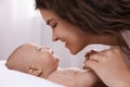 Happy young mother with her cute baby on bed at home, closeup Royalty Free Stock Photo