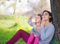 Happy young mother and her daughter blowing soap bubbles Royalty Free Stock Photo