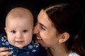 Happy young mother with her daughter on her hands on a black bac Royalty Free Stock Photo