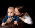 Happy young mother with her daughter on her hands on a black bac Royalty Free Stock Photo