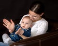 Happy young mother with her daughter on her hands on a black bac Royalty Free Stock Photo