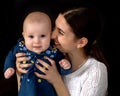 Happy young mother with her daughter on her hands on a black bac Royalty Free Stock Photo