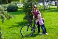 happy young mother with her daughter riding bicyc