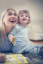 Happy young mother and her son painting color book. Royalty Free Stock Photo