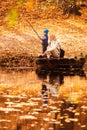 Happy young mother and her son spending time in the autumn park near the pond. Royalty Free Stock Photo