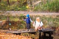 Happy young mother and her son spending time in the autumn park near the pond. Royalty Free Stock Photo