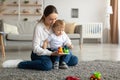 Happy young mother and her toddler son engaged in interesting game, playing educational games together Royalty Free Stock Photo