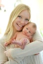 Happy Young Mother Holding Cuddly Newborn Baby