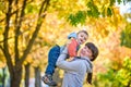 Happy young mother holding sweet toddler boy, family having fun together outside on a nice sunny autumn day. Cute adorable kid and Royalty Free Stock Photo