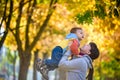 Happy young mother holding sweet toddler boy, family having fun together outside on a nice sunny autumn day. Cute adorable kid and Royalty Free Stock Photo