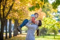 Happy young mother holding sweet toddler boy, family having fun together outside on a nice sunny autumn day. Cute adorable kid and Royalty Free Stock Photo