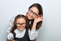 Happy young mother and lauging kid in fashion eye glasses hugging