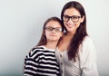 Happy young mother and lauging kid in fashion glasses hugging on empty copy space background. Family Royalty Free Stock Photo