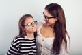 Happy young mother and lauging kid in fashion glasses hugging on empty copy space background. Family Royalty Free Stock Photo