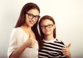 Happy young mother and lauging kid in fashion glasses hugging and showing thumb up on empty copy space background. Family Royalty Free Stock Photo