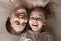 Happy young mother lying on floor with small kid.