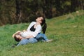 Happy young mother is playing with her baby in a park on a green lawn. Happiness and harmony of family life. Great family vacation