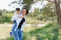 Happy young mother is playing with her baby in a park on a green lawn. Happiness and harmony of family life. Great family vacation